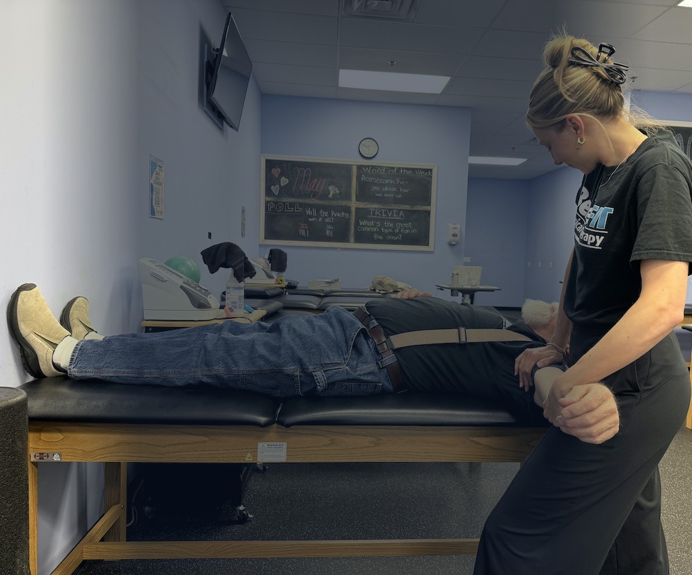 Physical therapist assisting a patient with leg mobility treatment at BeneFIT Physical Therapy in Chester, NJ